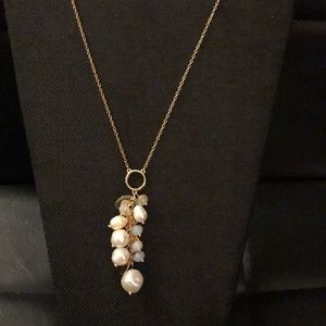Gold necklace with white beads.